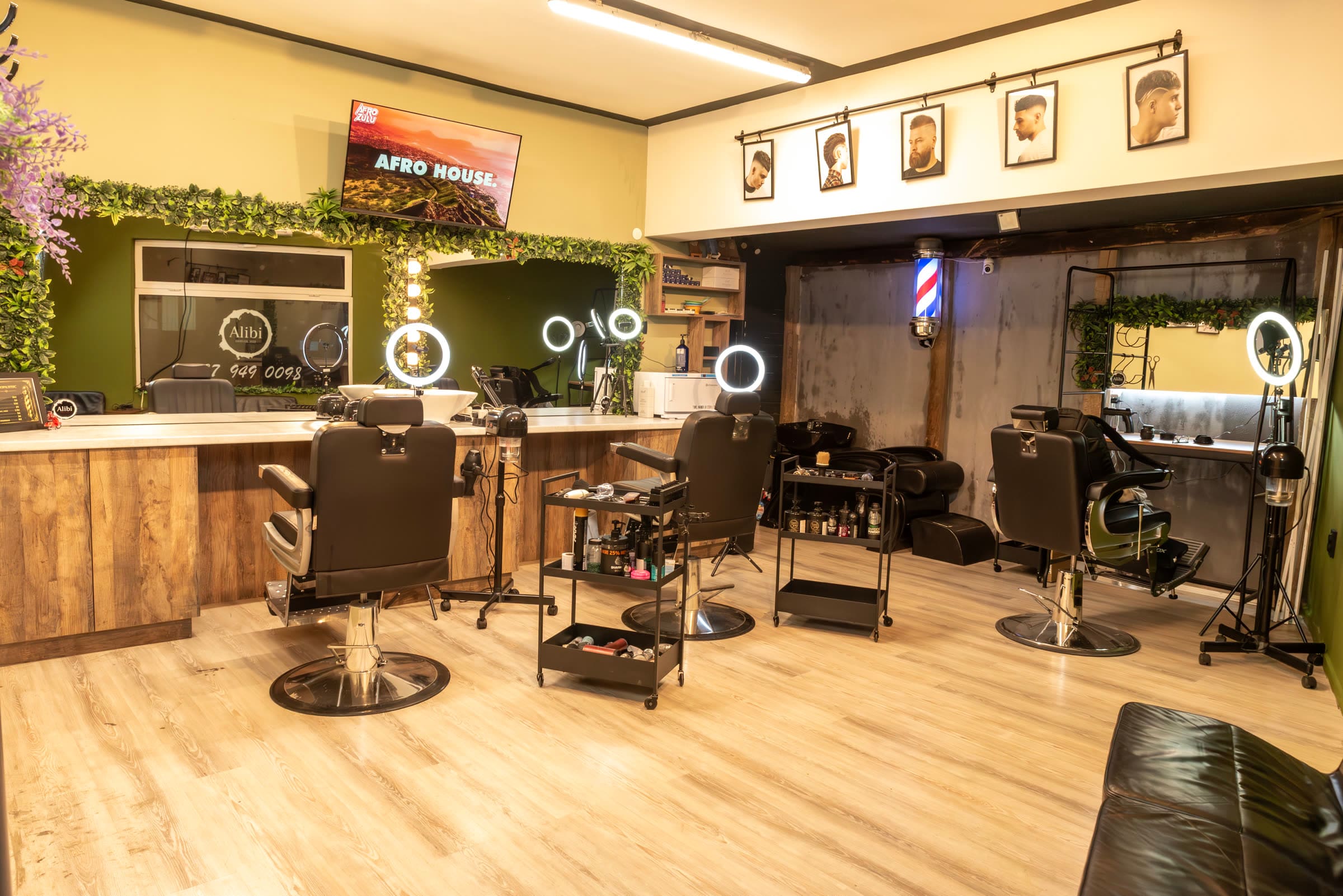 Просторният интериор на Alibi Salon с модерни бръснарски столове и огледала с LED осветление